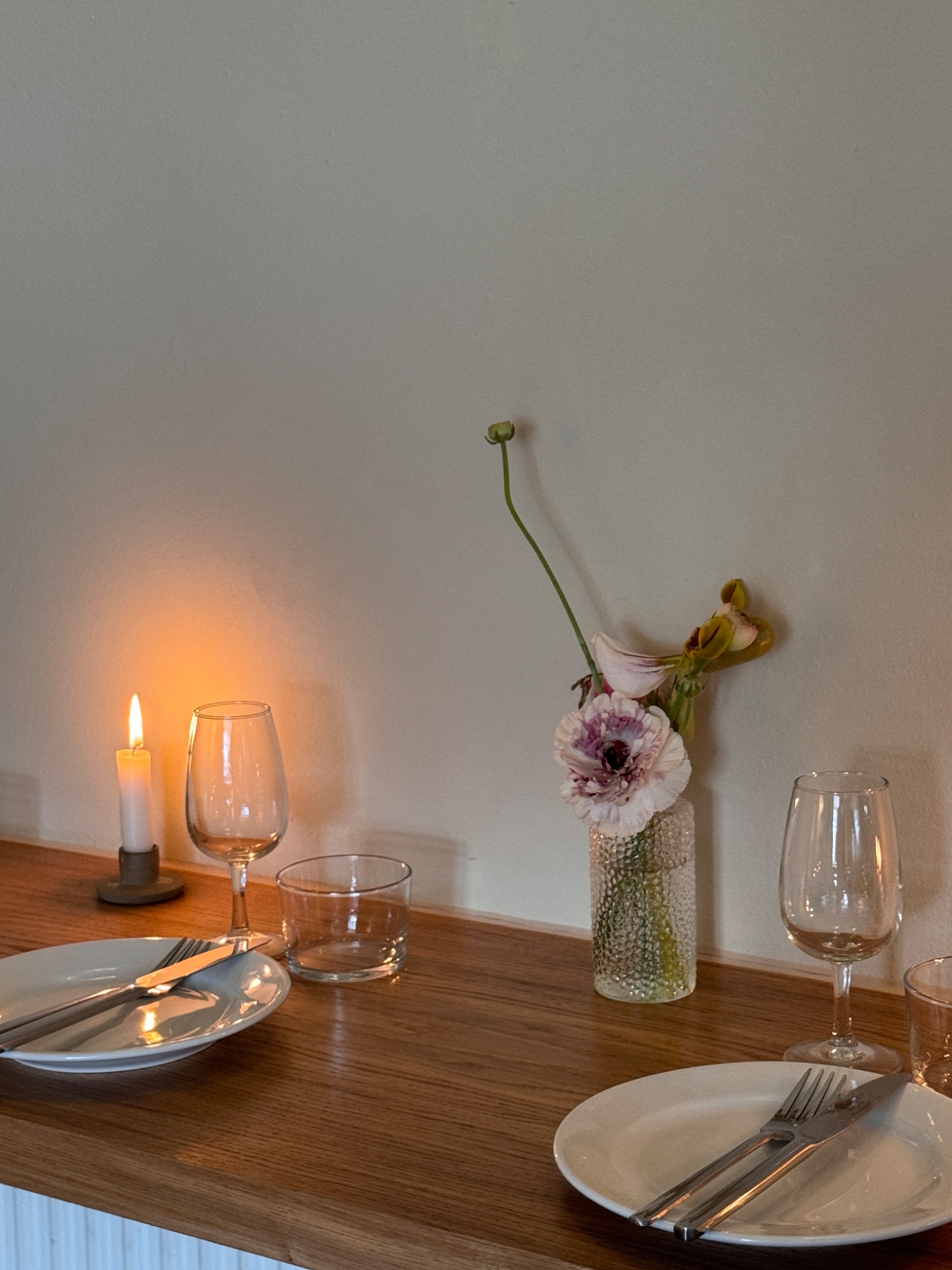 A candlelit table set with flowers and glassware
