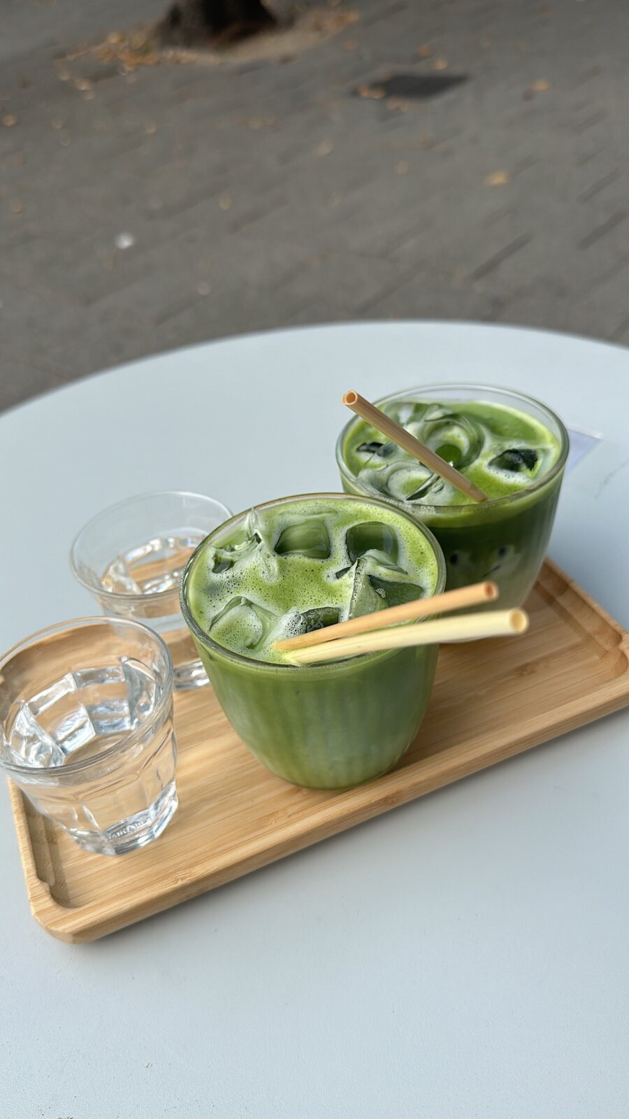 Three iced matcha drinks arranged on a tray