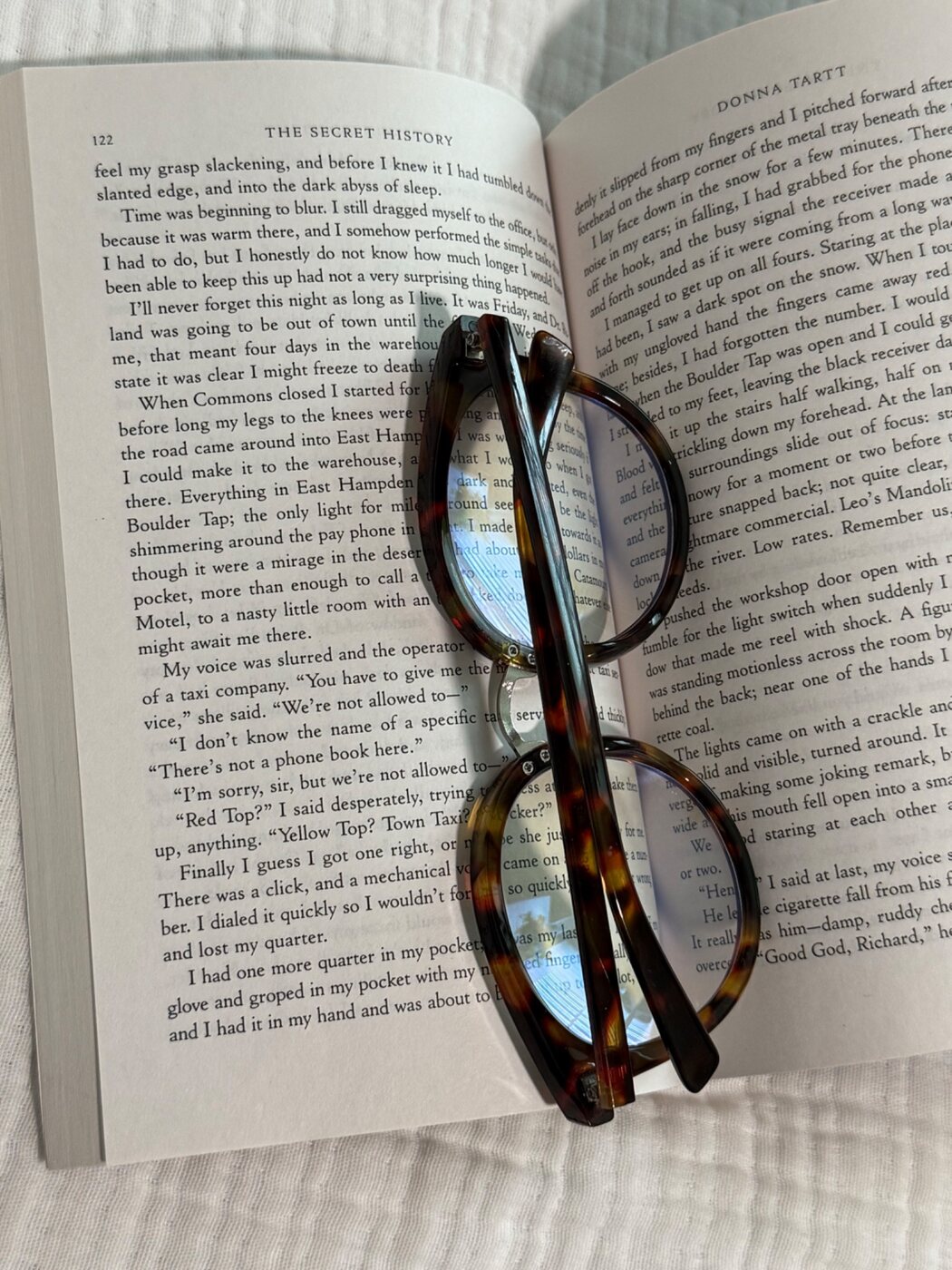 Open book with tortoiseshell glasses