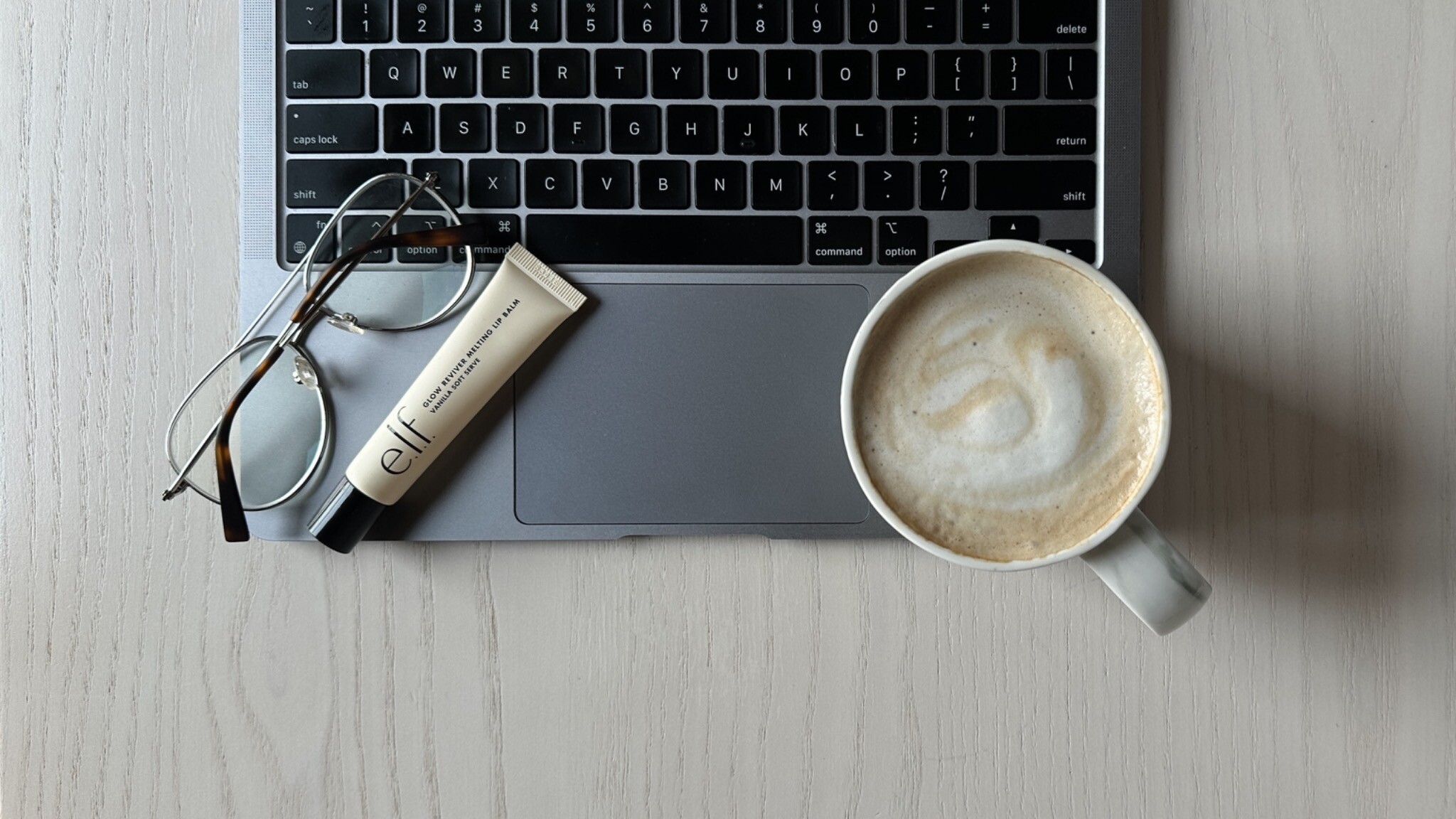 Laptop, keyboard, glasses and coffee arranged on a Sunday School workspace